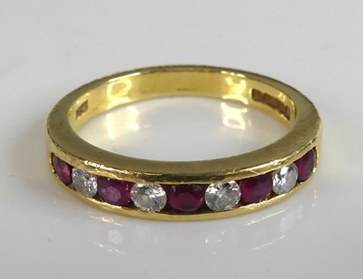 Lot 2762 - An 18ct yellow gold ruby and diamond half hoop...