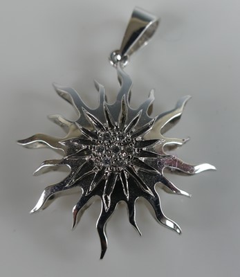Lot 2588 - A white metal sun pendant, having a centre...