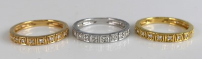 Lot 2584 - Three diamond half hoop eternity rings, in...