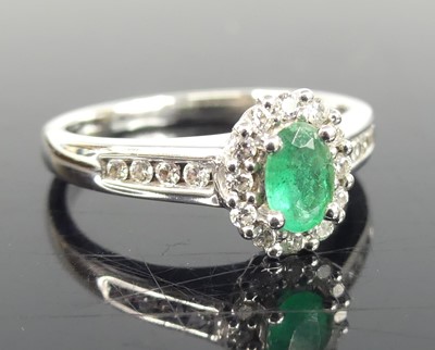 Lot 2745 - An 18ct white gold, emerald and diamond oval...