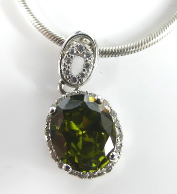 Lot 2849 - A contemporary green peridot pendant, the oval...