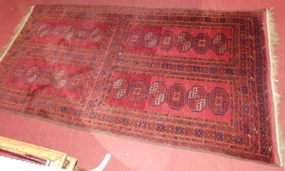 Lot 1133 - A Persian woollen red ground bokhara rug, 210...