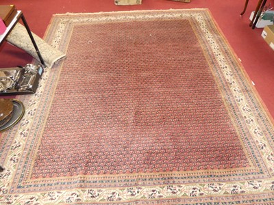 Lot 1143 - A Persian woollen red ground rug, with...