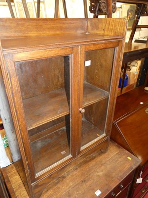 Lot 1216 - A small 1930s oak low twin door glazed...