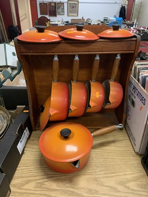 Lot 676 - A graduated set of five Le Creuset orange...