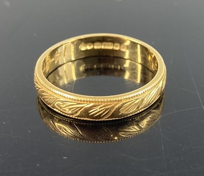 Lot 369 - A modern 18ct gold wedding band with carved...