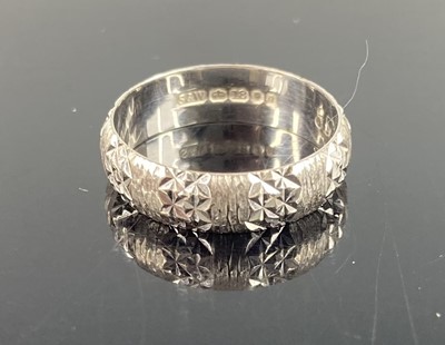 Lot 390 - An 18ct bright cut white gold wedding band,...