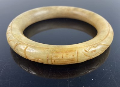 Lot 409 - A Chinese carved nephrite bangle