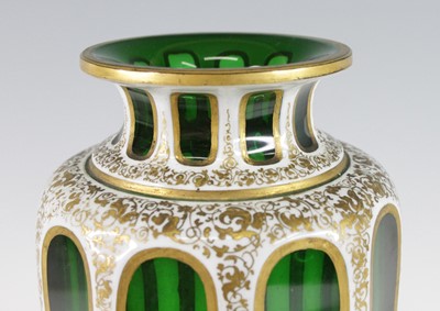 Lot 2055 - A Bohemian green and white overlaid glass vase,...