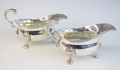 Lot 2125 - A pair of George V silver sauceboats, having...