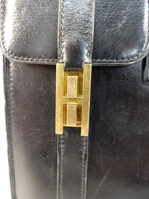 Lot 602 - A Hermès black leather drag-up handbag,...