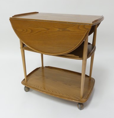 Lot 787 - An Ercol blond elm dropflap three-tier tea...