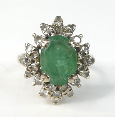 Lot 2182 - A white metal, emerald and diamond oval...