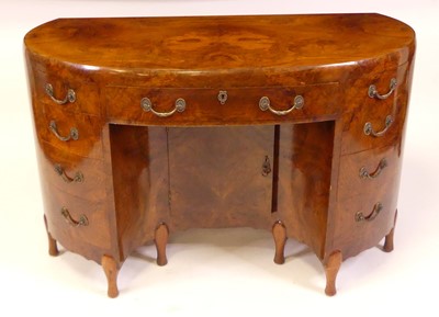 Lot 774 - An Art Deco figured walnut kneehole desk by...