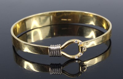 Lot 2228 - A contemporary 18ct gold bangle having a noose...