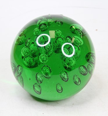 Lot 33 - A large green glass paperweight, having bubble...