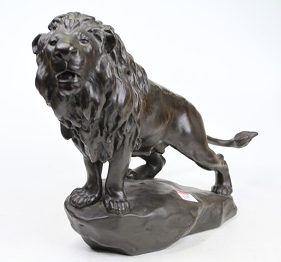 Lot 128 - A bronzed model of a lion, shown in standing...