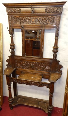 Lot 1165 - A circa 1900 heavily relief carved oak mirror...