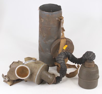 Lot 619 - A WWII rubber gas mask in painted metal tin