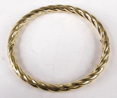 Lot 420 - A hollow yellow metal ropetwist bangle,...