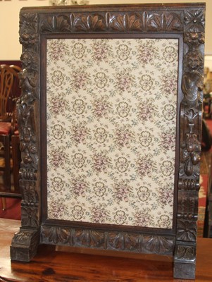 Lot 1302 - A relief carved oak fire screen having floral...