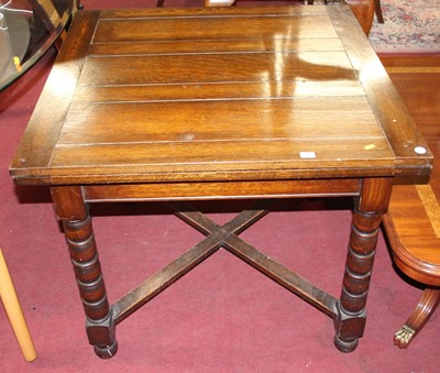 Lot 1313 - A 1930s oak draw-leaf dining table, raised on...