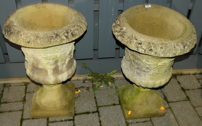 Lot 1415 - A pair of reconstituted stone pedestal urn...