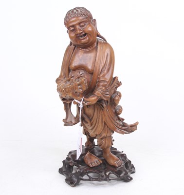 Lot 34 - A Chinese carved hardwood figure of a man...