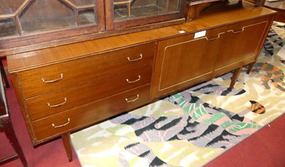 Lot 1311 - A 1960s teak veneered sideboard, having three...