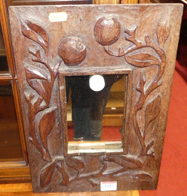 Lot 1115 - An Arts & Crafts carved oak framed wall mirror,...