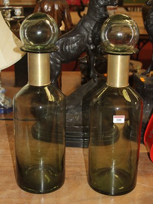 Lot 100 - A pair of large green glass bottles, each h.54cm