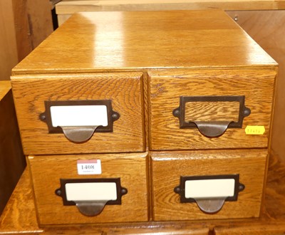 Lot 1408 - A 1930s oak table-top bank of four index...