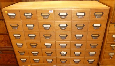 Lot 1414 - A 1930s blond oak bank of 36 index filing...