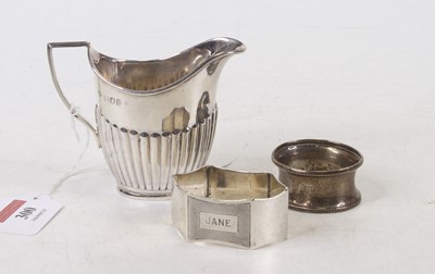 Lot 300 - A silver cream jug of half reeded helmet form,...