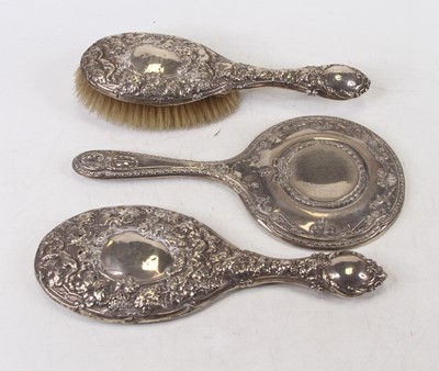 Lot 309 - A silver and embossed backed hand mirror...