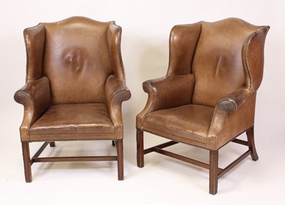 Lot 1583 - A pair of tan leather upholstered wing...