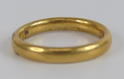 Lot 2516 - A yellow metal 3.2mm court shaped wedding band,...