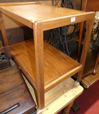 Lot 1244 - A 1970s teak two-tier tea trolley on roller...