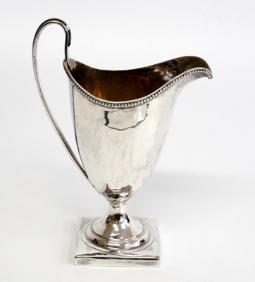 Lot 1145 - A George III silver helmet shaped cream jug,...