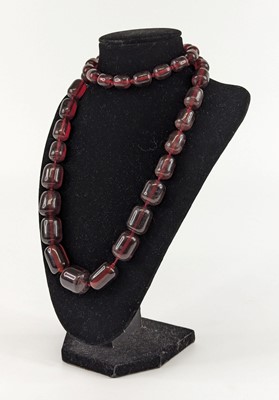 Lot 121 - A cherry amber coloured bakelite bead necklace,...