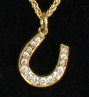 Lot 1239 - An 18ct yellow gold diamond set horseshoe...