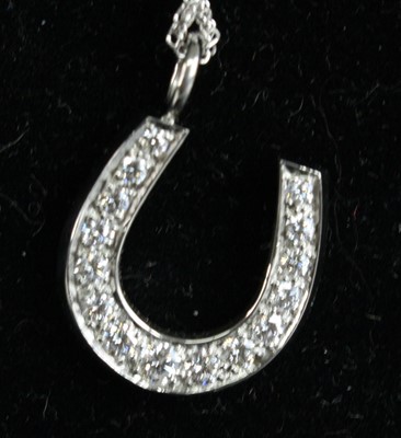 Lot 1238 - A white metal diamond set horseshoe pendant,...