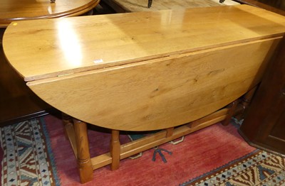Lot 1390 - A contemporary blond oak dropleaf dining table,...