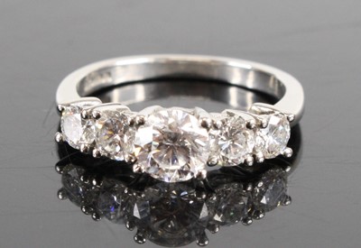 Lot 1294 - A platinum diamond five-stone half hoop ring,...