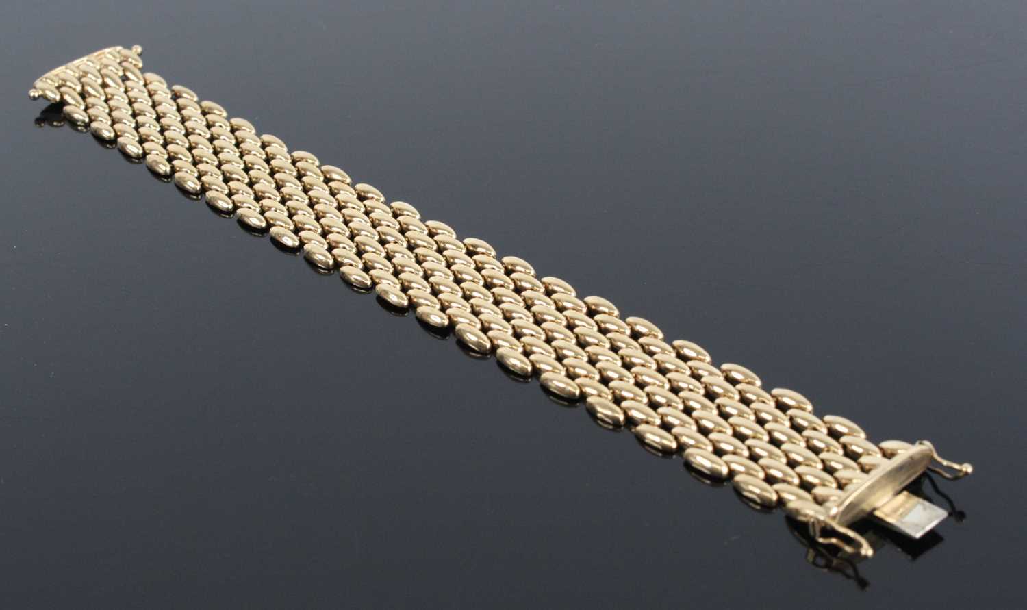 Lot 1243 - A 9ct yellow gold five-row brick link bracelet,...