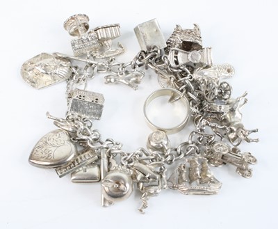 Lot 342 - A silver charm bracelet containing numerous...