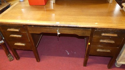 Lot 1243 - A 1930s oak kneehole writing desk, having an...