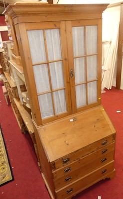 Lot 1385 - A pine bureau bookcase, having twin glazed...