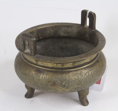 Lot 232 - A Chinese brass tripod censer, decorated with...