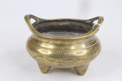 Lot 290 - A Chinese brass tripod censer, decorated with...